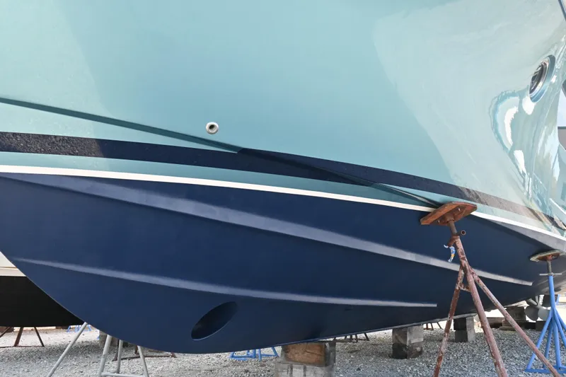 Present Tense Yacht Photos Pics 2017 Tiara 44 Coupe boat hull on stands, showcasing sleek design and blue color.