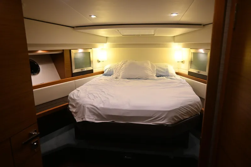 Present Tense Yacht Photos Pics Luxurious bedroom interior of 2017 Tiara 44 Coupe yacht with cozy lighting. Nighttime view