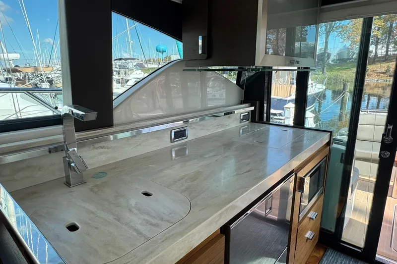 Present Tense Yacht Photos Pics Luxurious 2017 Tiara 44 Coupe yacht interior with modern kitchen and marina view.