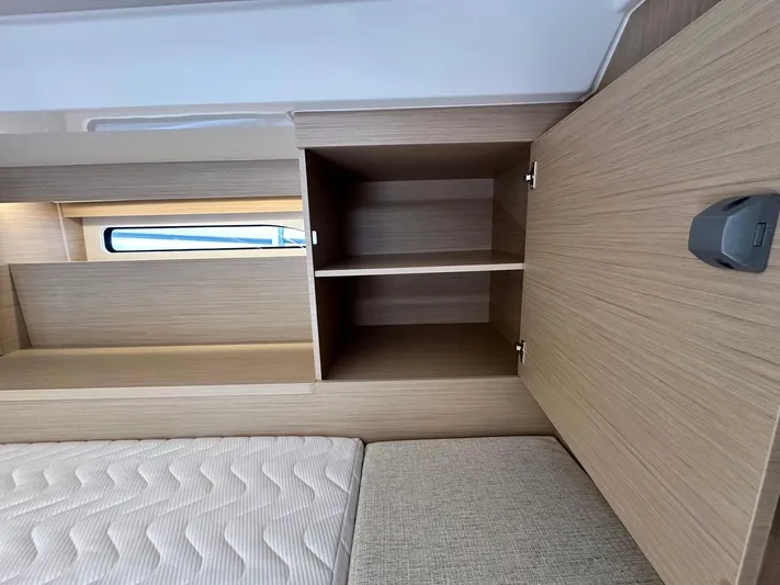  Yacht Photos Pics 2025 Jeanneau DB/37 OB interior with wooden cabinetry and mattress.