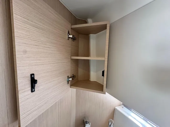  Yacht Photos Pics Open wooden cabinet inside 2025 Jeanneau DB/37 OB boat interior.