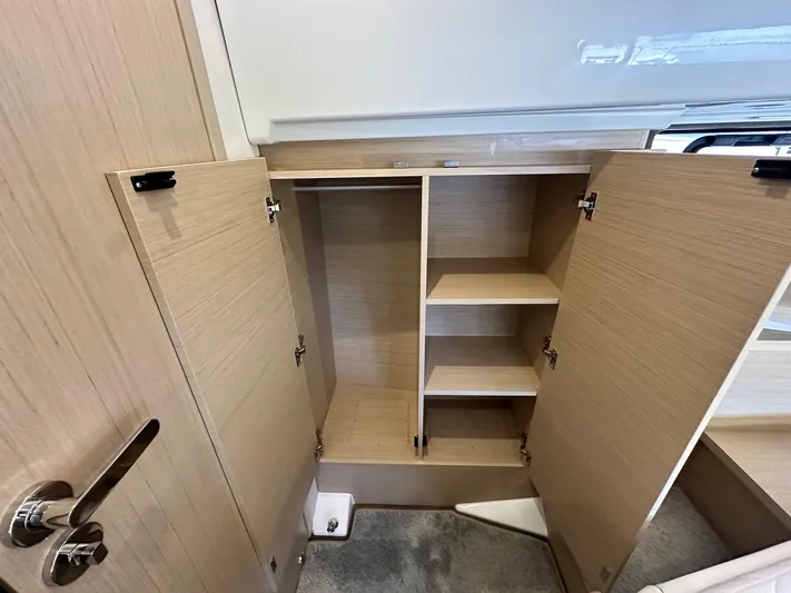  Yacht Photos Pics Interior storage cabinets on the 2025 Jeanneau DB/37 OB boat, featuring wooden shelves and doors.