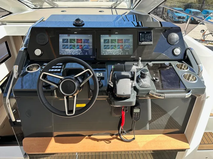  Yacht Photos Pics 2025 Jeanneau DB/37 OB helm with dual screens, steering wheel, and control panel.