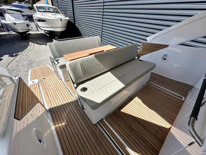  Yacht Photos Pics 2025 Jeanneau DB/37 OB boat interior with cushioned seating and wooden flooring.