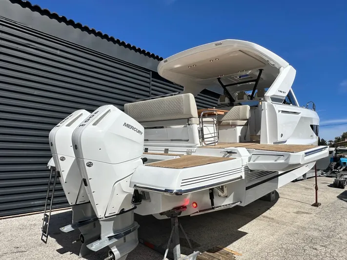  Yacht Photos Pics 2025 Jeanneau DB/37 OB boat with dual Mercury outboard engines, docked under clear blue sky.