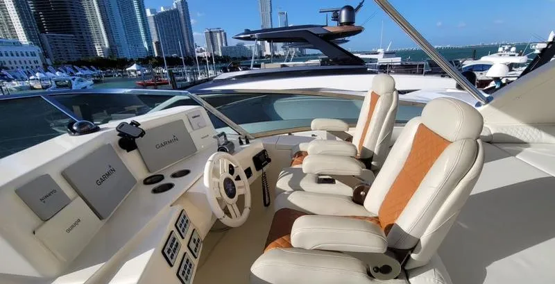 Thinks It's His Too Yacht Photos Pics 2008 Azimut Flybridge yacht helm with luxurious seating and modern controls, docked in a marina.