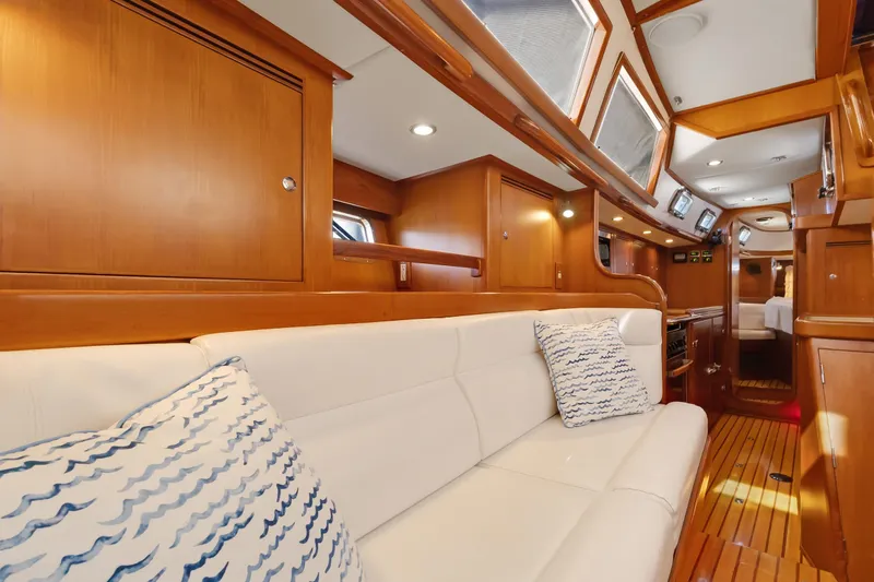 Avventura Yacht Photos Pics Luxurious interior of 2009 Hylas 46 yacht with white seating and wooden cabinetry.