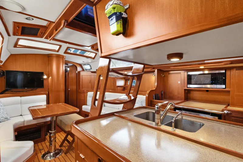 Avventura Yacht Photos Pics Luxurious interior of a 2009 Hylas 46 yacht with wood finishes and modern amenities.
