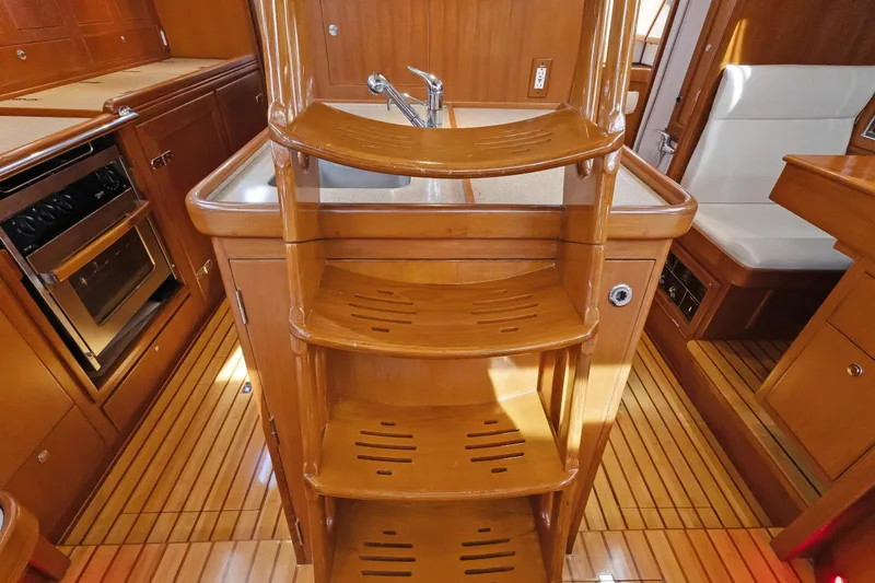 Avventura Yacht Photos Pics Interior of 2009 Hylas 46 yacht with wooden cabinetry and compact kitchen.