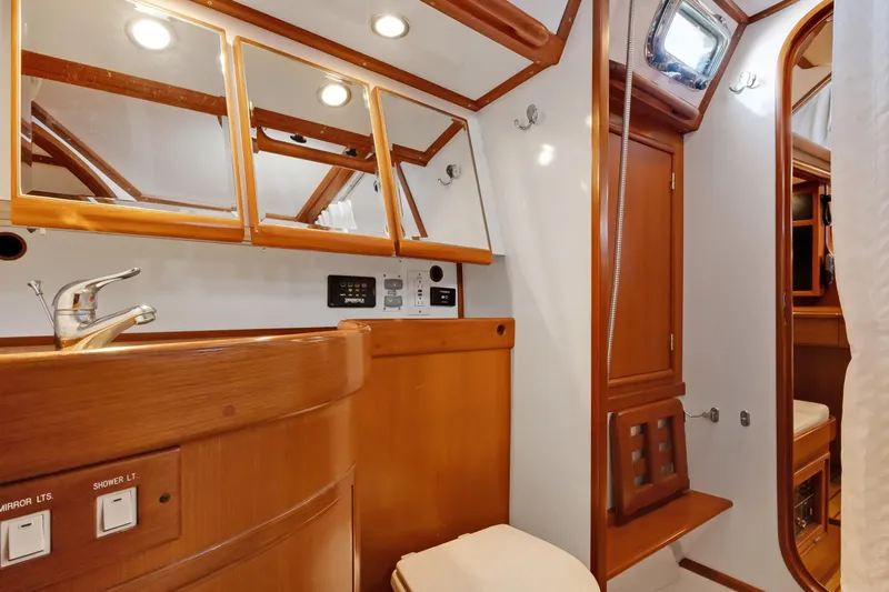 Avventura Yacht Photos Pics Luxurious 2009 Hylas 46 yacht bathroom with wooden cabinetry and modern fixtures.