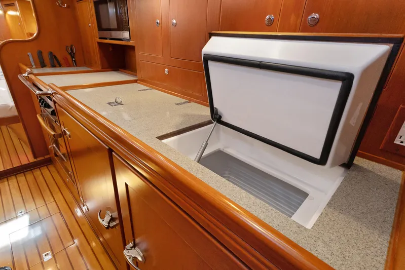 Avventura Yacht Photos Pics Luxurious 2009 Hylas 46 yacht interior with wooden cabinetry and open storage compartment.