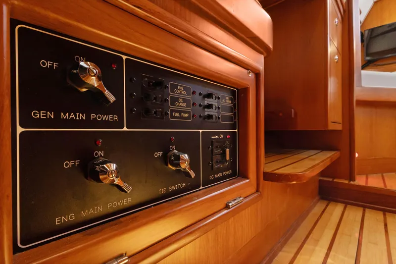 Avventura Yacht Photos Pics Control panel inside 2009 Hylas 46 yacht, featuring power switches and wooden interior.