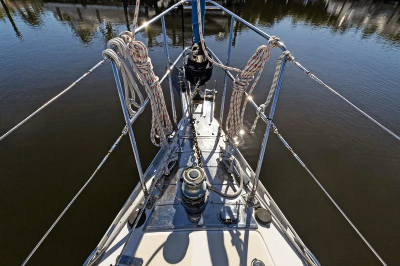 Avventura Yacht Photos Pics Bow of 2009 Hylas 46 sailboat with ropes and winch, reflecting sunlight on water.