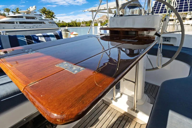 Avventura Yacht Photos Pics Polished wooden table on 2009 Hylas 46 yacht deck, with marina view.