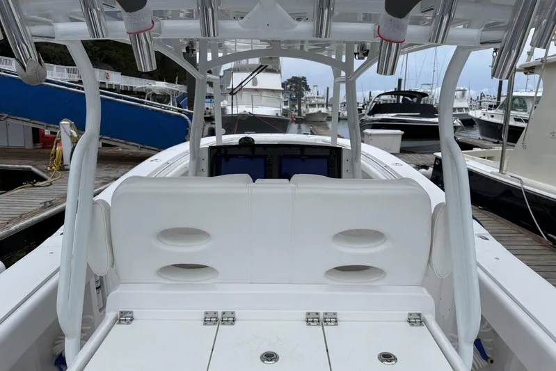  Yacht Photos Pics 2018 Southport 33 FE boat interior at marina, featuring white seating and rod holders.