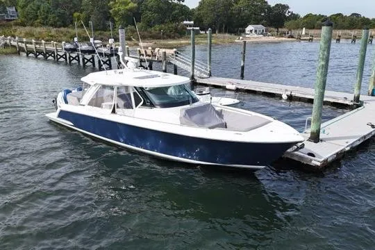Carry On Yacht Photos Pics 2021 Tiara Sport 43 LS boat docked at a marina, featuring sleek design and blue hull.