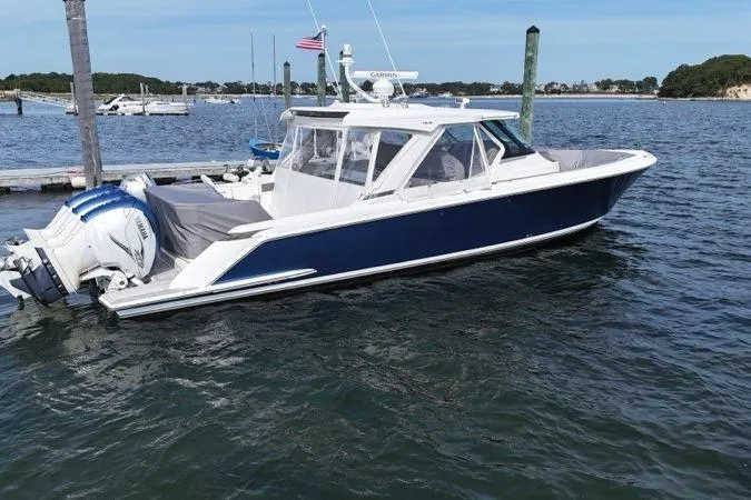 Carry On Yacht Photos Pics 2021 Tiara Sport 43 LS boat docked on calm water, featuring sleek design and powerful engines.