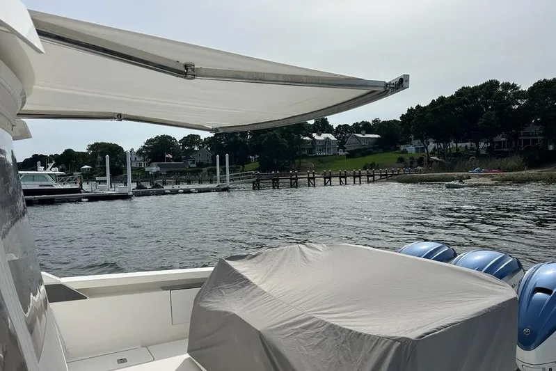 Carry On Yacht Photos Pics 2021 Tiara Sport 43 LS yacht with covered engines docked by a scenic waterfront.