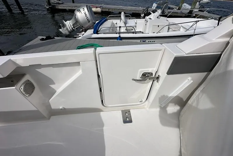 Carry On Yacht Photos Pics 2021 Tiara Sport 43 LS boat deck with open hatch and docked motorboat.