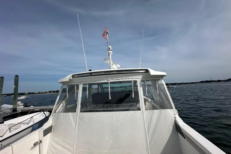 Carry On Yacht Photos Pics 2021 Tiara Sport 43 LS boat docked with American flag, clear sky, and calm waters.
