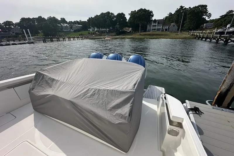 Carry On Yacht Photos Pics 2021 Tiara Sport 43 LS boat with covered engines docked by a scenic waterfront.