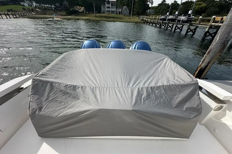 Carry On Yacht Photos Pics 2021 Tiara Sport 43 LS boat with covered engines, docked by a scenic waterfront.