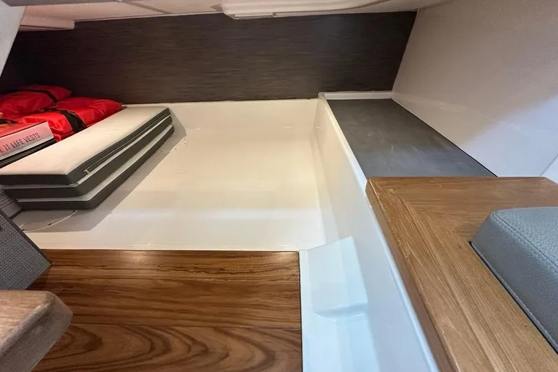 Carry On Yacht Photos Pics 2021 Tiara Sport 43 LS interior cabin with life vests and wooden flooring.