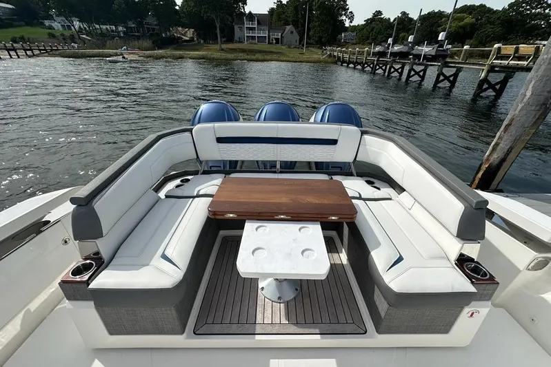 Carry On Yacht Photos Pics Luxury seating area on 2021 Tiara Sport 43 LS boat, docked by a scenic waterfront.
