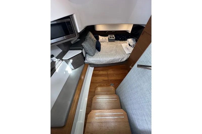 Carry On Yacht Photos Pics Interior cabin of 2021 Tiara Sport 43 LS with bed, microwave, and wooden steps.