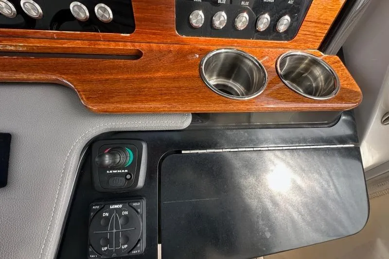 Carry On Yacht Photos Pics 2021 Tiara Sport 43 LS dashboard with wood paneling, cup holders, and control switches.