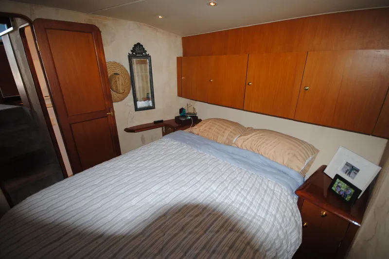  Yacht Photos Pics Cozy bedroom in 1999 Ocean Yachts 45 Super Sport with wood cabinets and striped bedding.