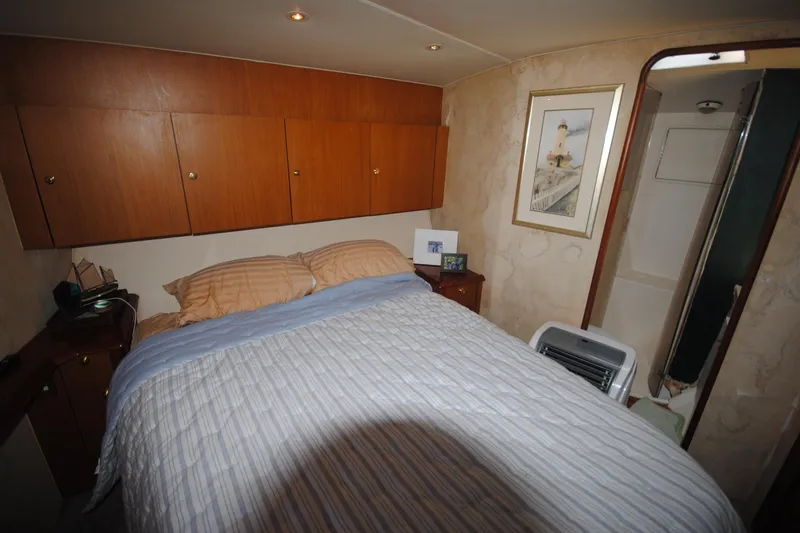  Yacht Photos Pics Cozy bedroom in 1999 Ocean Yachts 45 Super Sport with wood cabinets and nautical decor.