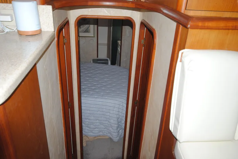  Yacht Photos Pics Interior view of 1999 Ocean Yachts 45 Super Sport cabin with bed and wooden accents.