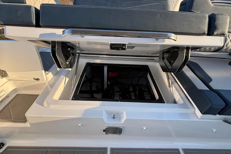  Yacht Photos Pics 2026 Monterey Elite 30 OB boat with open storage compartment and cushioned seating.