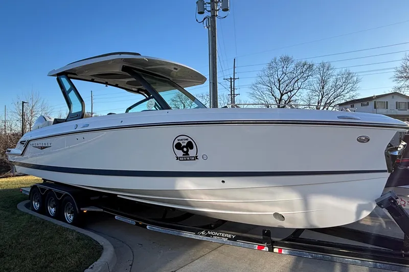  Yacht Photos Pics 2026 Monterey Elite 30 OB boat on trailer, side view, outdoors.