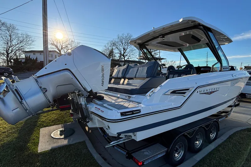  Yacht Photos Pics 2026 Monterey Elite 30 OB boat with Mercury outboard engine on a trailer, sunny day.