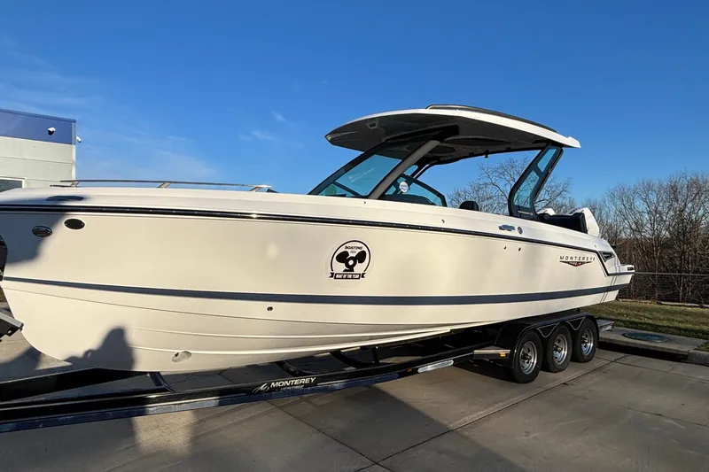  Yacht Photos Pics 2026 Monterey Elite 30 OB boat on trailer, sleek design, clear blue sky background.