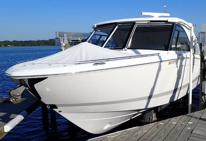  Yacht Photos Pics 2023 Regal LX36 boat docked by the water on a sunny day.
