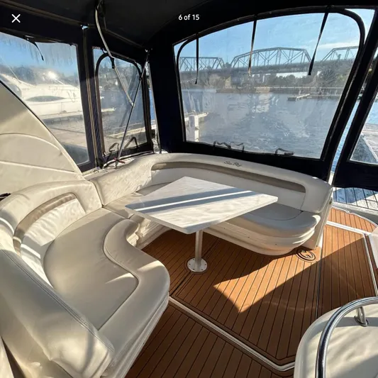  Yacht Photos Pics Interior of 2005 Sea Ray 340 Sundancer with white seating and wooden flooring.