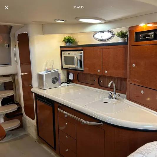  Yacht Photos Pics 2005 Sea Ray 340 Sundancer interior kitchen with wood cabinets, sink, and microwave.