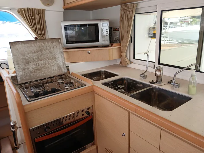 Patange II Yacht Photos Pics Interior of 2009 Lagoon 440 yacht kitchen with stove, microwave, and dual sinks.