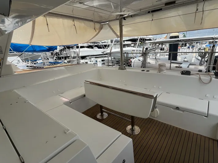 Patange II Yacht Photos Pics 2009 Lagoon 440 yacht cockpit with seating, wooden flooring, and marina view.