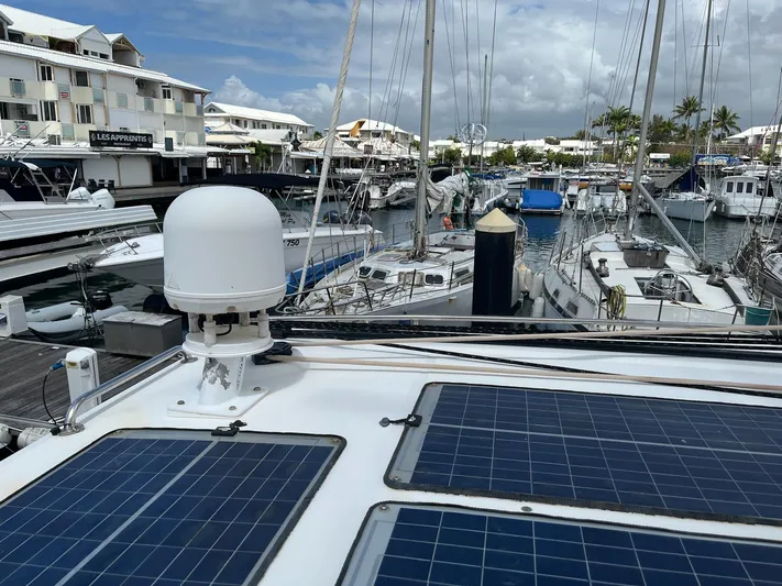 Patange II Yacht Photos Pics Lagoon 440 catamaran (2009) with solar panels docked in a marina.