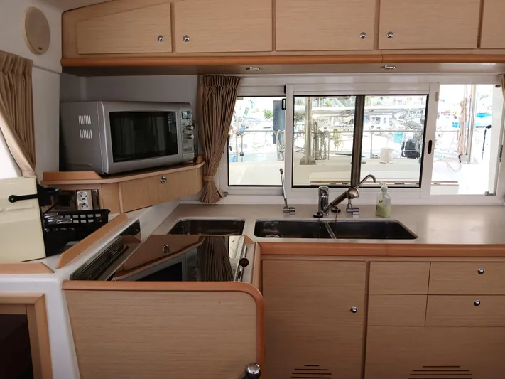 Patange II Yacht Photos Pics 2009 Lagoon 440 yacht kitchen with microwave, stove, sink, and window view.