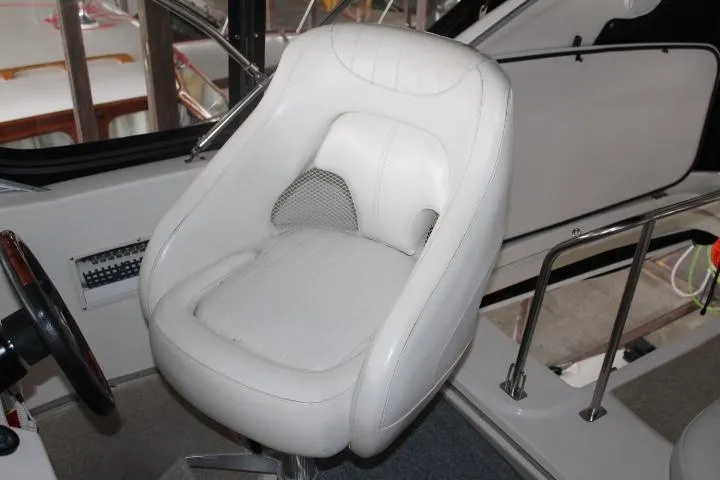 Mad Mary Yacht Photos Pics Captain's chair in 2004 Meridian 381 Sedan boat cockpit, featuring white upholstery and modern design.