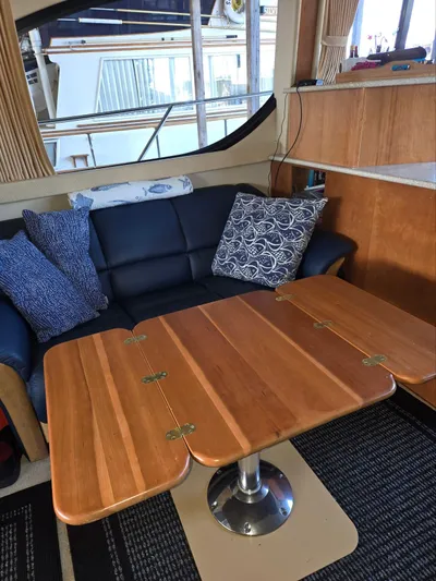 Mad Mary Yacht Photos Pics Interior of a 2004 Meridian 381 Sedan with a wooden table and cushioned seating.