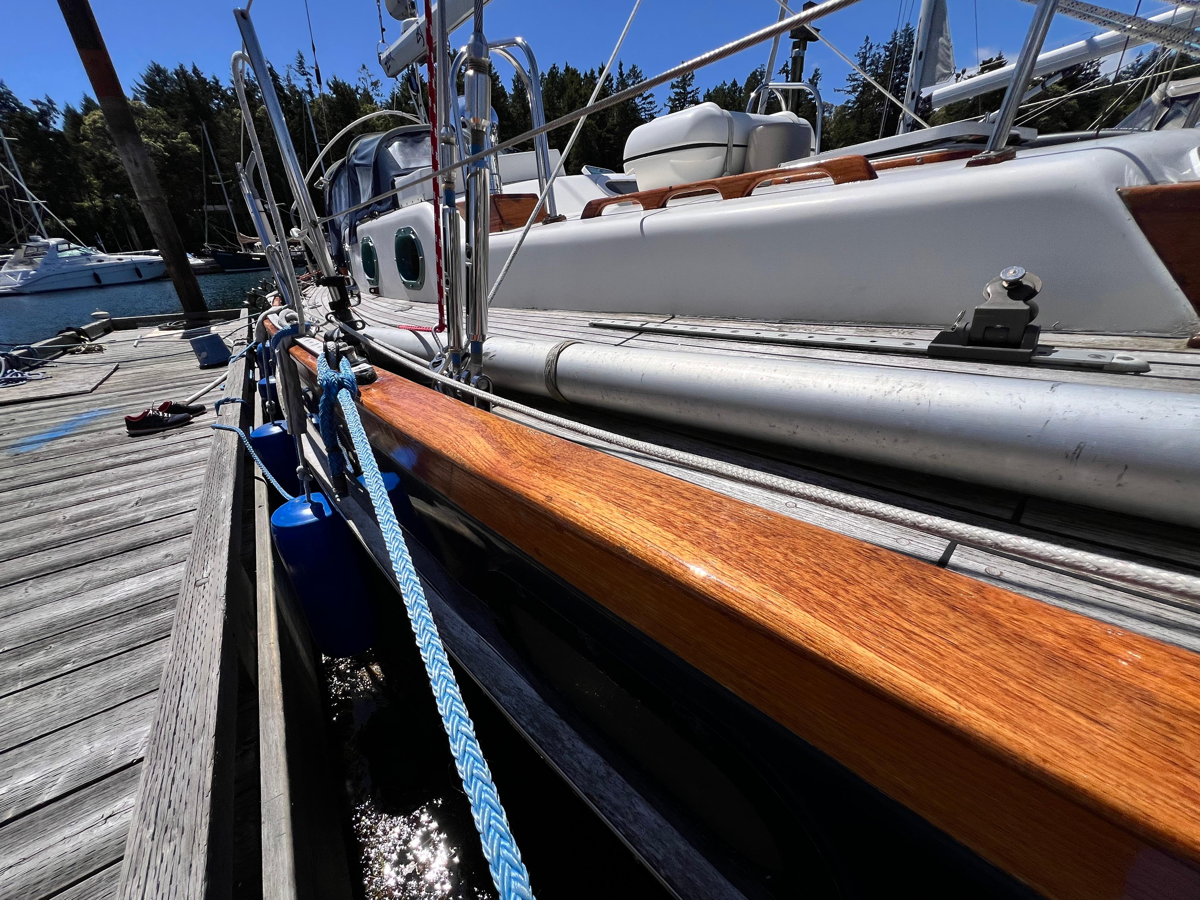 Sailboat Reliance 45, 1987 model, docked with polished wood and blue ropes.