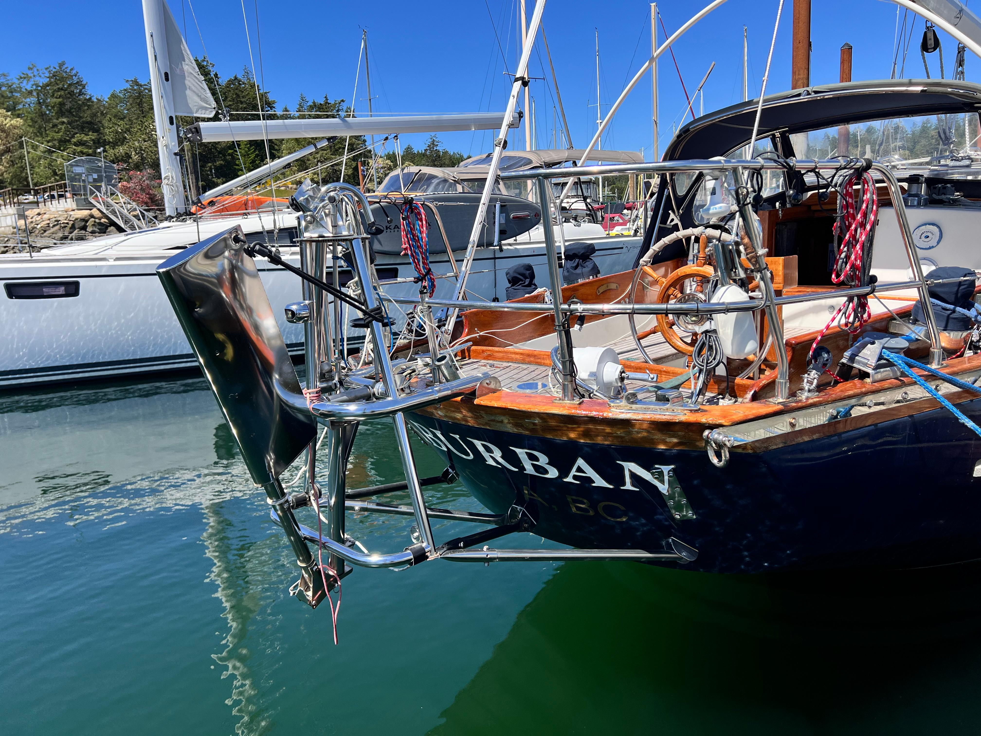 Sailboat "Reliance 45" from 1987 docked in a marina, featuring polished metalwork.