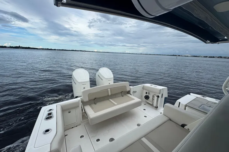  Yacht Photos Pics 2023 Boston Whaler 380 Realm boat on calm waters, showcasing spacious deck and dual engines.