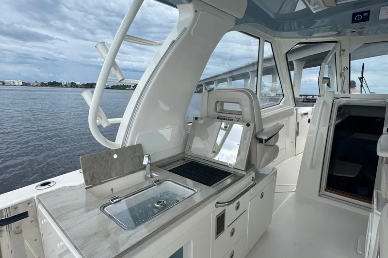  Yacht Photos Pics 2018 Boston Whaler 380 Realm interior with sink and seating, overlooking calm waters.